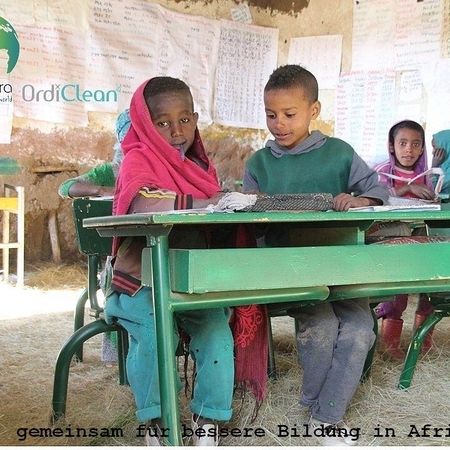 Zwei Kinder aus Afrika an einer Schulbank