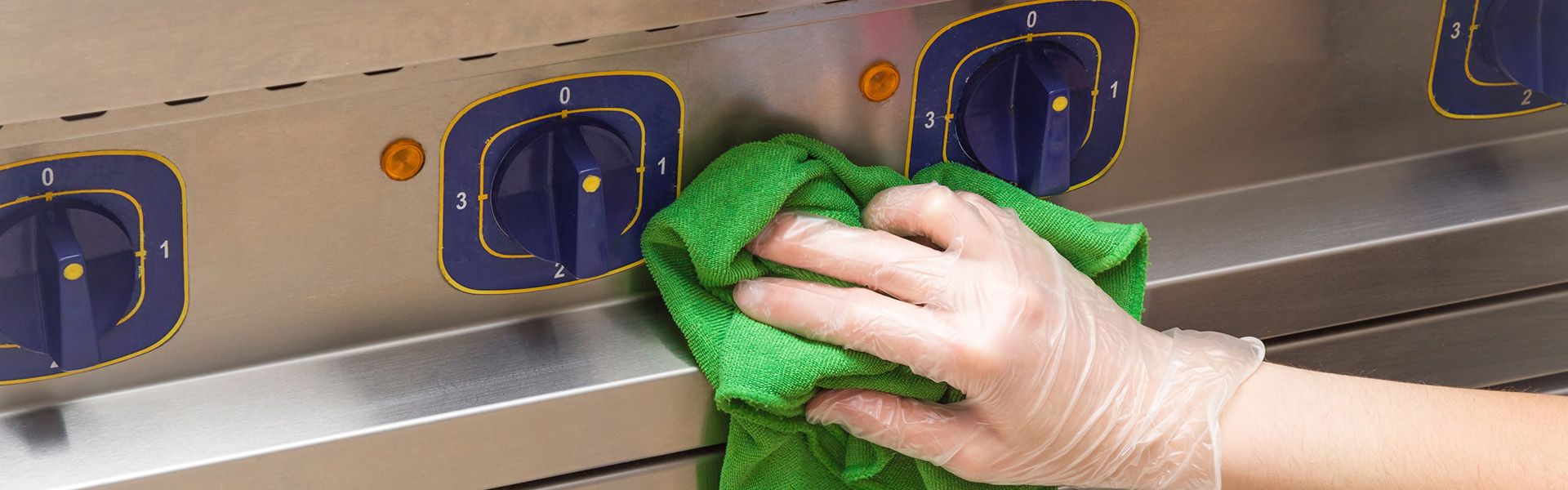 Eine Person mit Gummihandschuhen und eine grünen Lappen