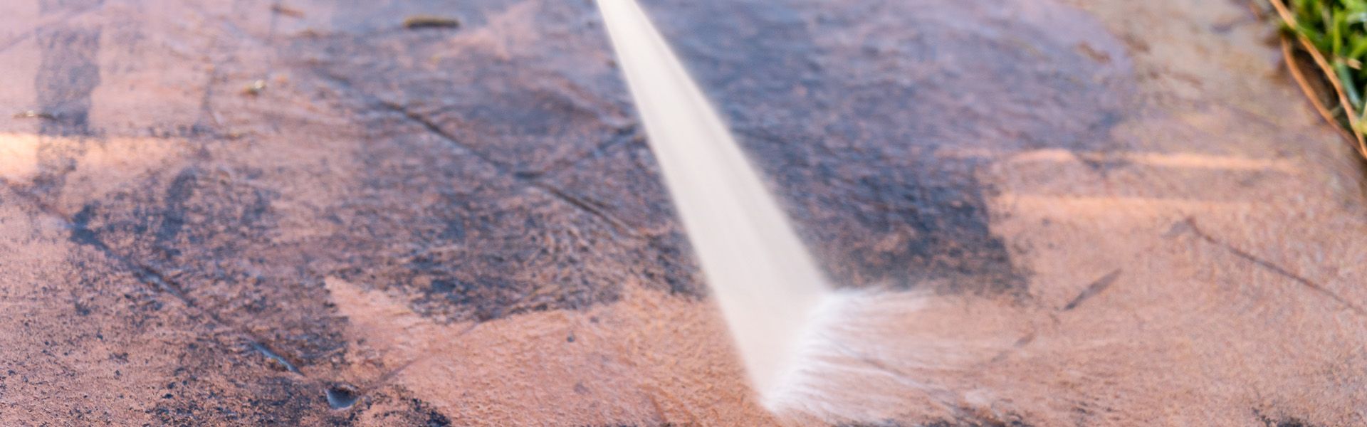 Ein Steinboden der mit einem Hochdruckreiniger gereinigt wird.